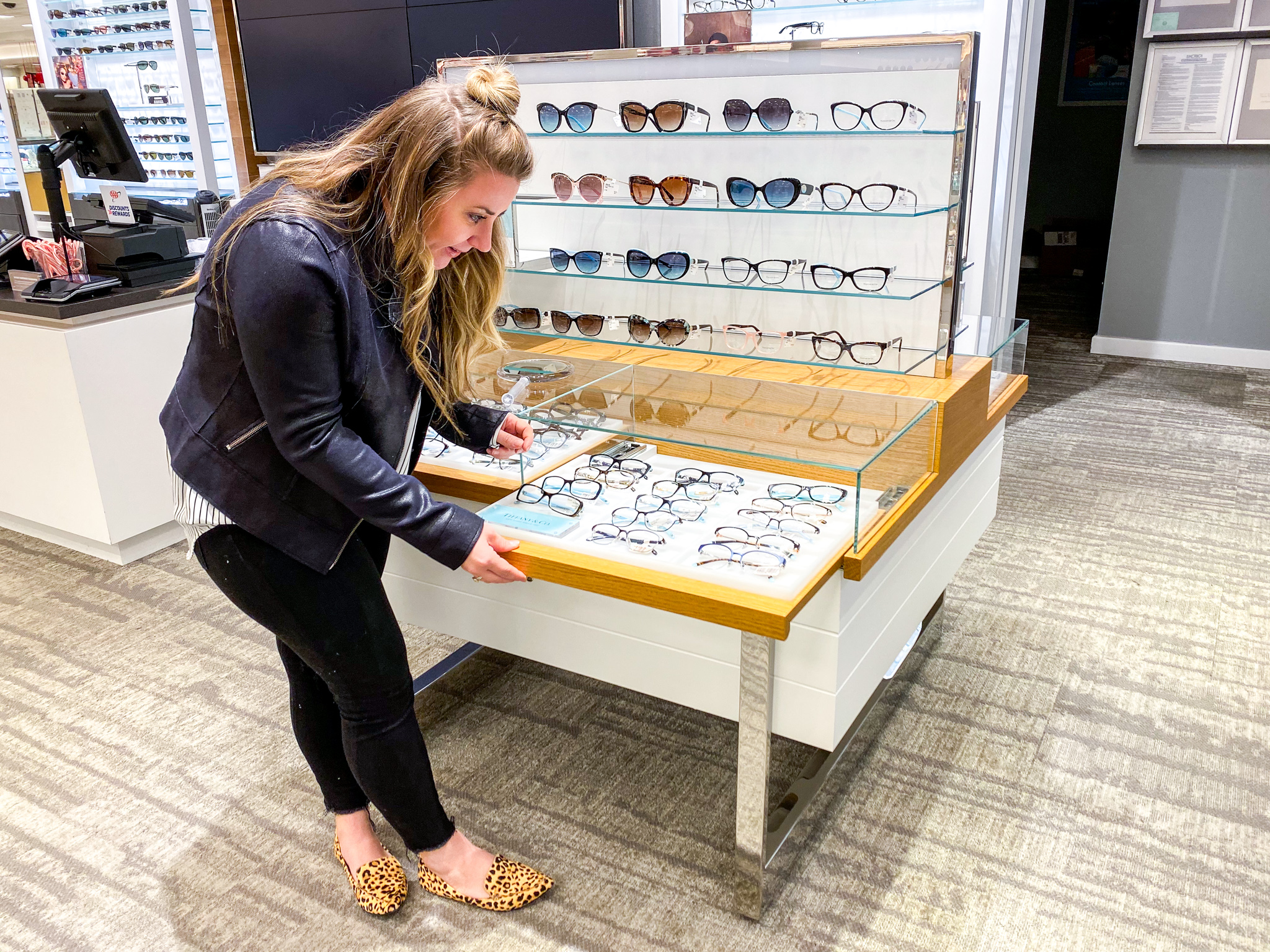 New Glasses with Lenscrafters at Macys by popular North Carolina life and style blog, Coffee Beans an Bobby Pins: image of a woman looking at glasses in Lenscrafters at Macys.