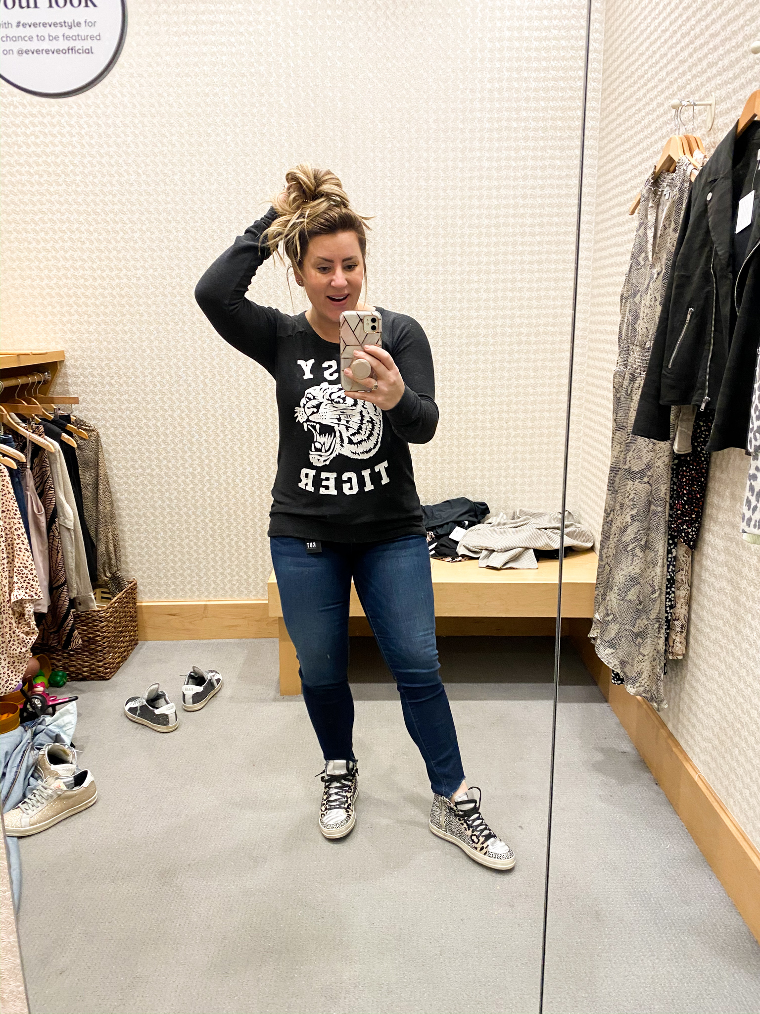 Evereve Outfits by popular Ohio fashion blog, Coffee Beans and Bobby Pins: image of a woman standing in a dressing room and wearing Evereve Agolde Sophie Crop, Evereve P448 Leopard Hightop Sneaker, and Evereve Chaser Easy Tiger Sweatshirt.