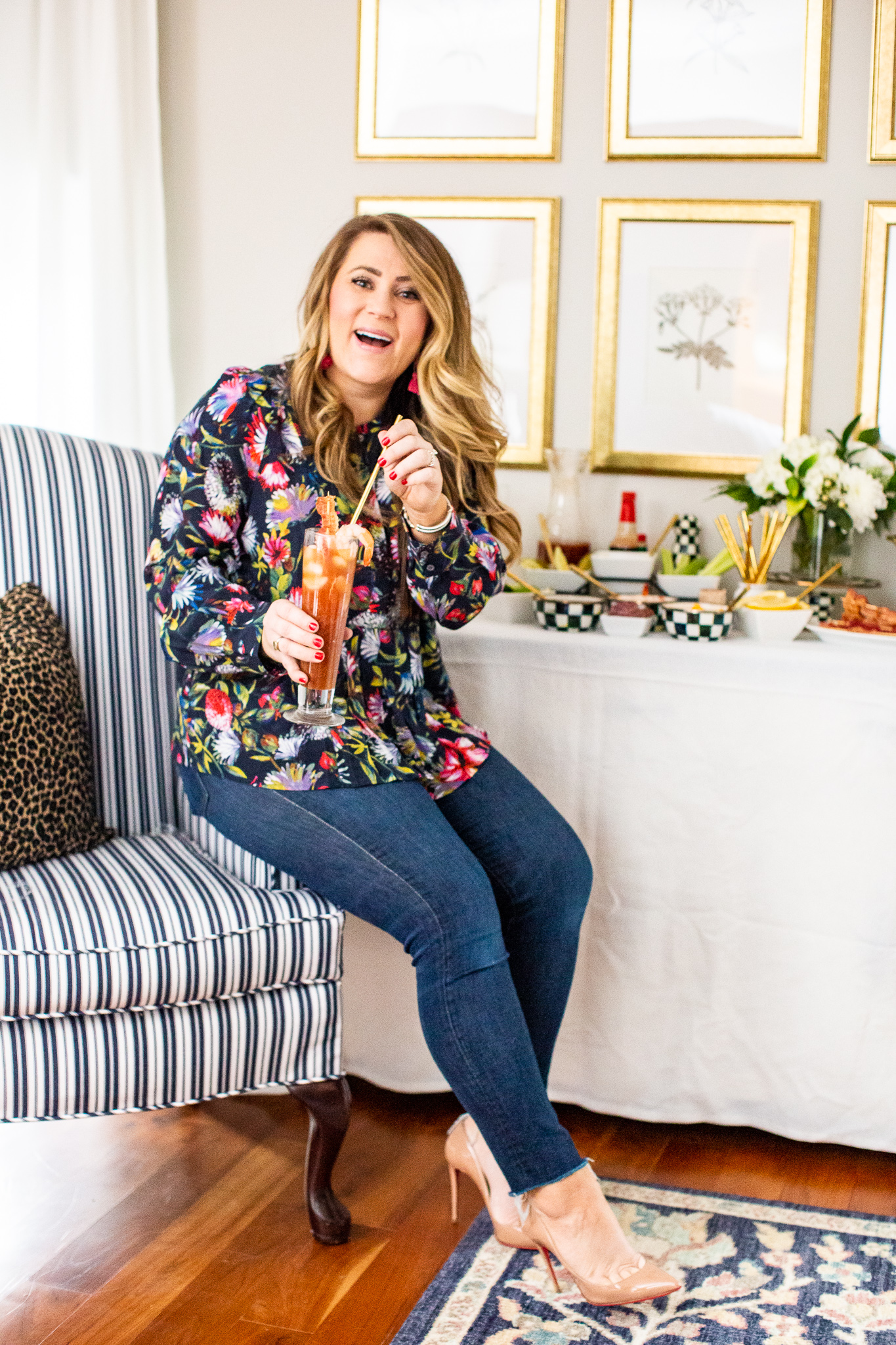 The Perfect Bloody Mary featured by top US lifestyle blog Coffee Beans and Bobby Pins; Woman in living room drinking a Bloody Mary