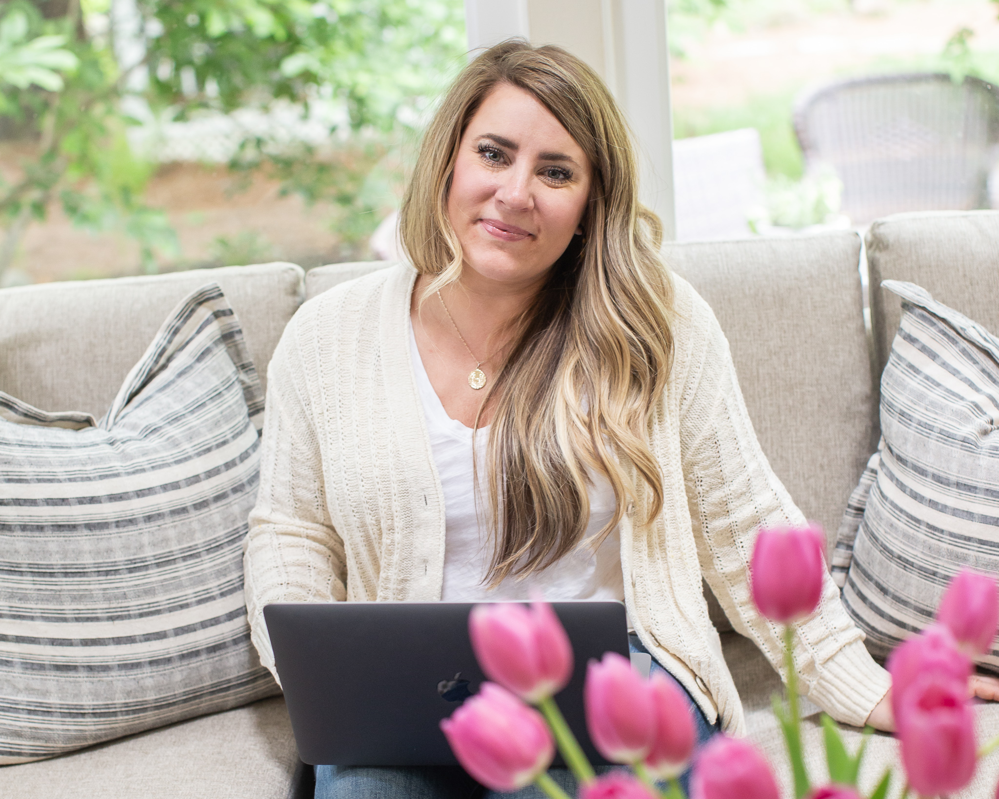 MyHeritage DNA Results by popular North Carolina fashion blog, Coffee Beans and Bobby Pins: image of a woman sitting on her couch with her laptop on her lap.