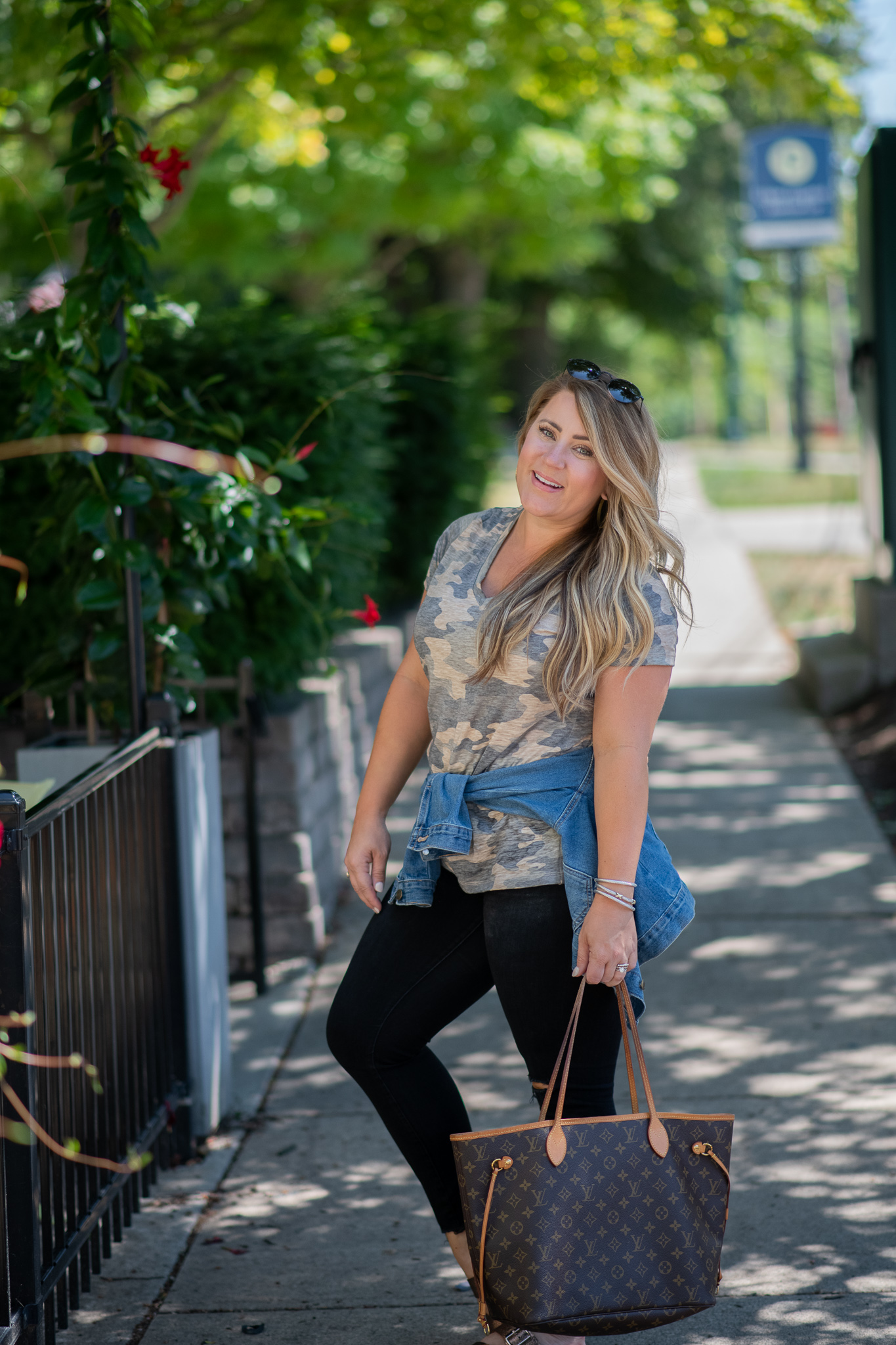 Back to School Style with Kohl's by popular North Carolina fashion blog, Coffee Beans and Bobby Pins: image of a woman standing outside and wearing a Kohl's MUDD camo tee, Kohl's distressed denim, Kohl's metallic slide sandals, and carrying a Louis Vuitton bag.