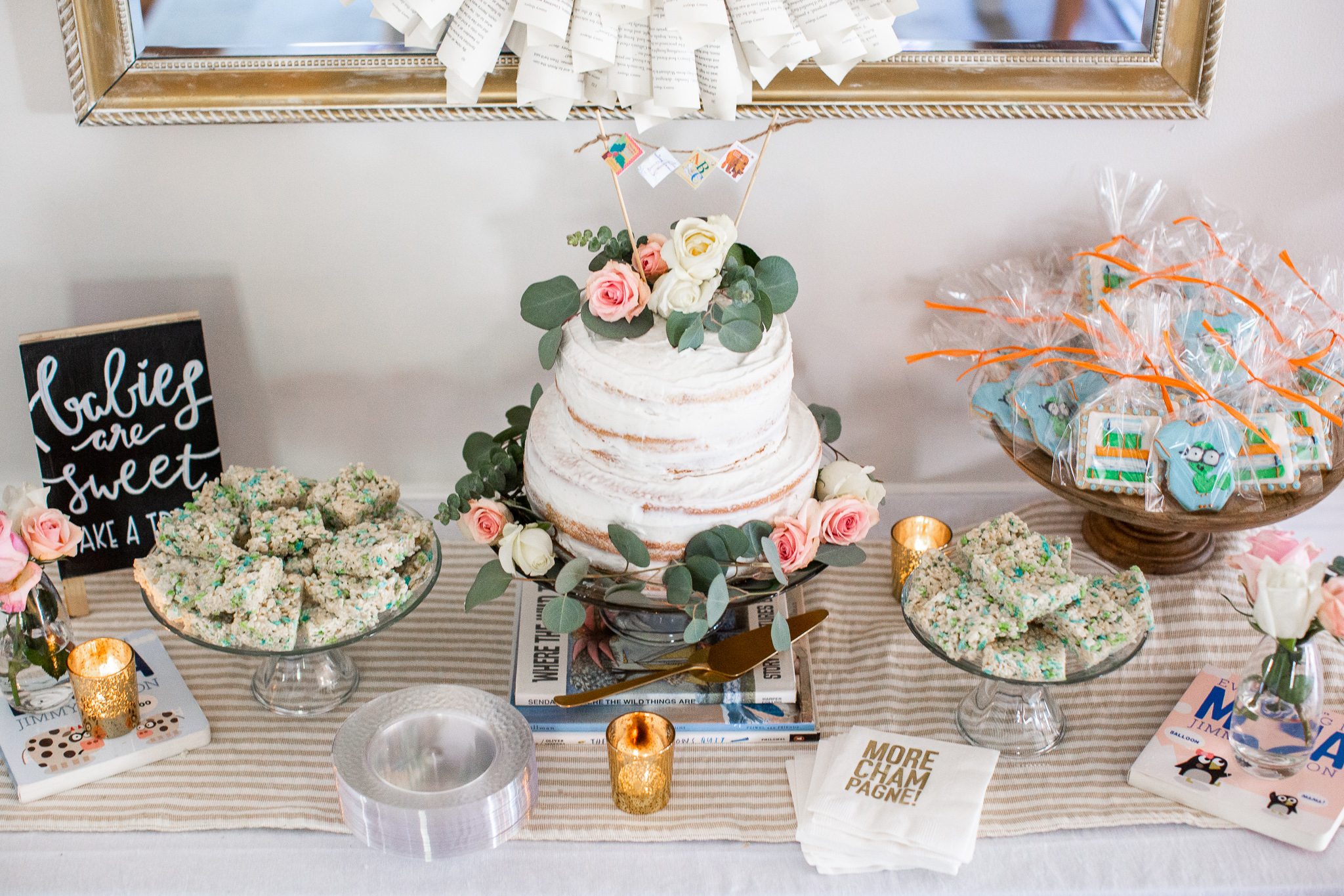  Story Book Baby Shower Ideas by popular North Carolina life and style blog, Coffee Beans and Bobby Pins: image of a two tier cake, rice krispie treats, candle votives, book worm cookies party favors, clear plastic plates, picture books, and a book page wreath.