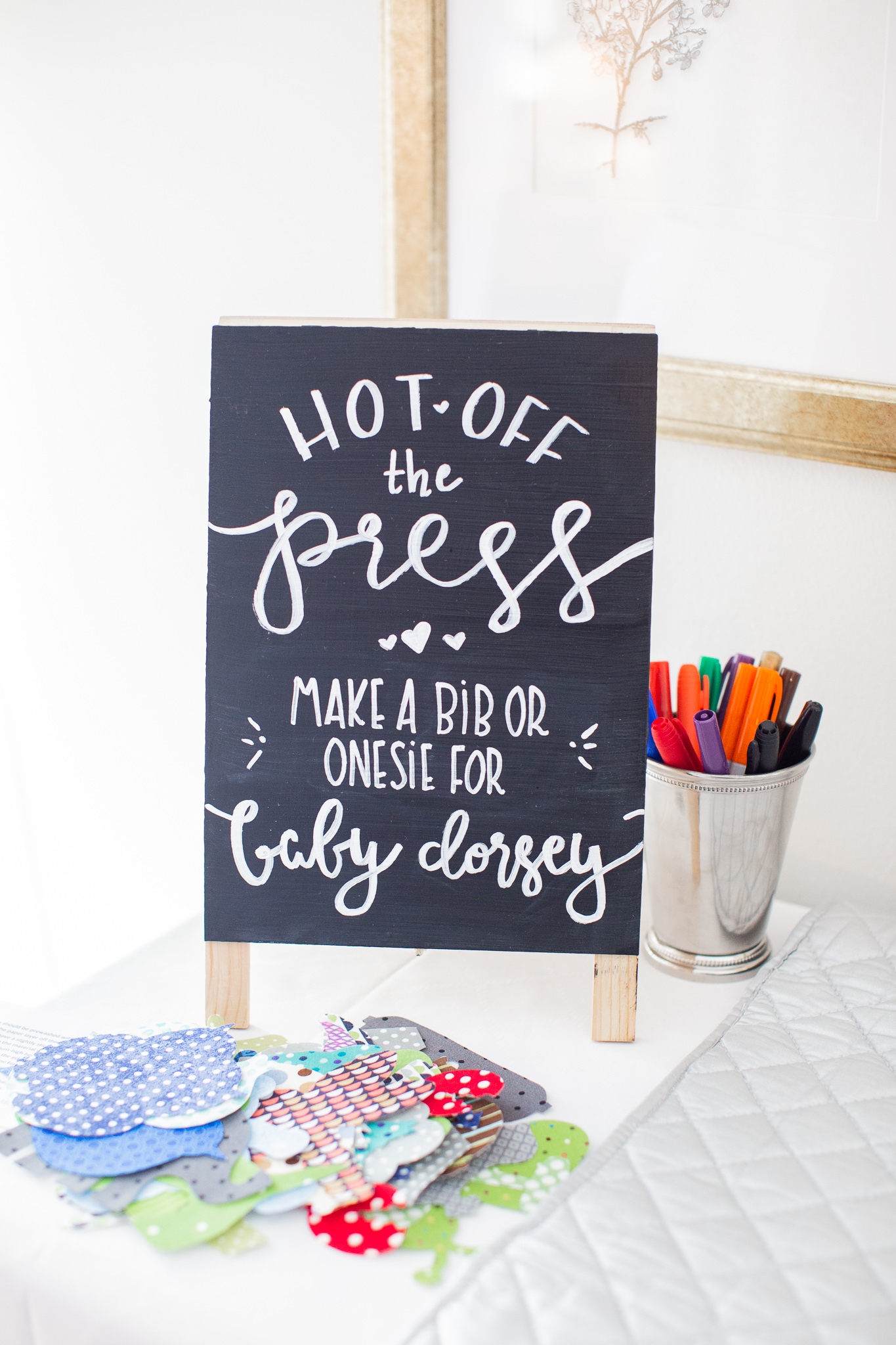  Story Book Baby Shower Ideas by popular North Carolina life and style blog, Coffee Beans and Bobby Pins: image of a onesie decorating station.