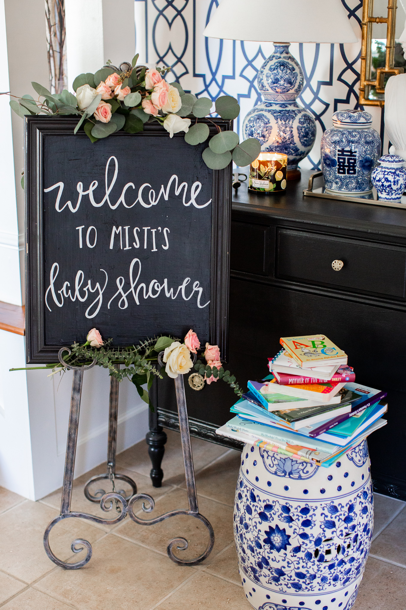 Story Book Baby Shower Ideas by popular North Carolina life and style blog, Coffee Beans and Bobby Pins: image of a chalkboard welcome sign next to a pile of children's picture books.