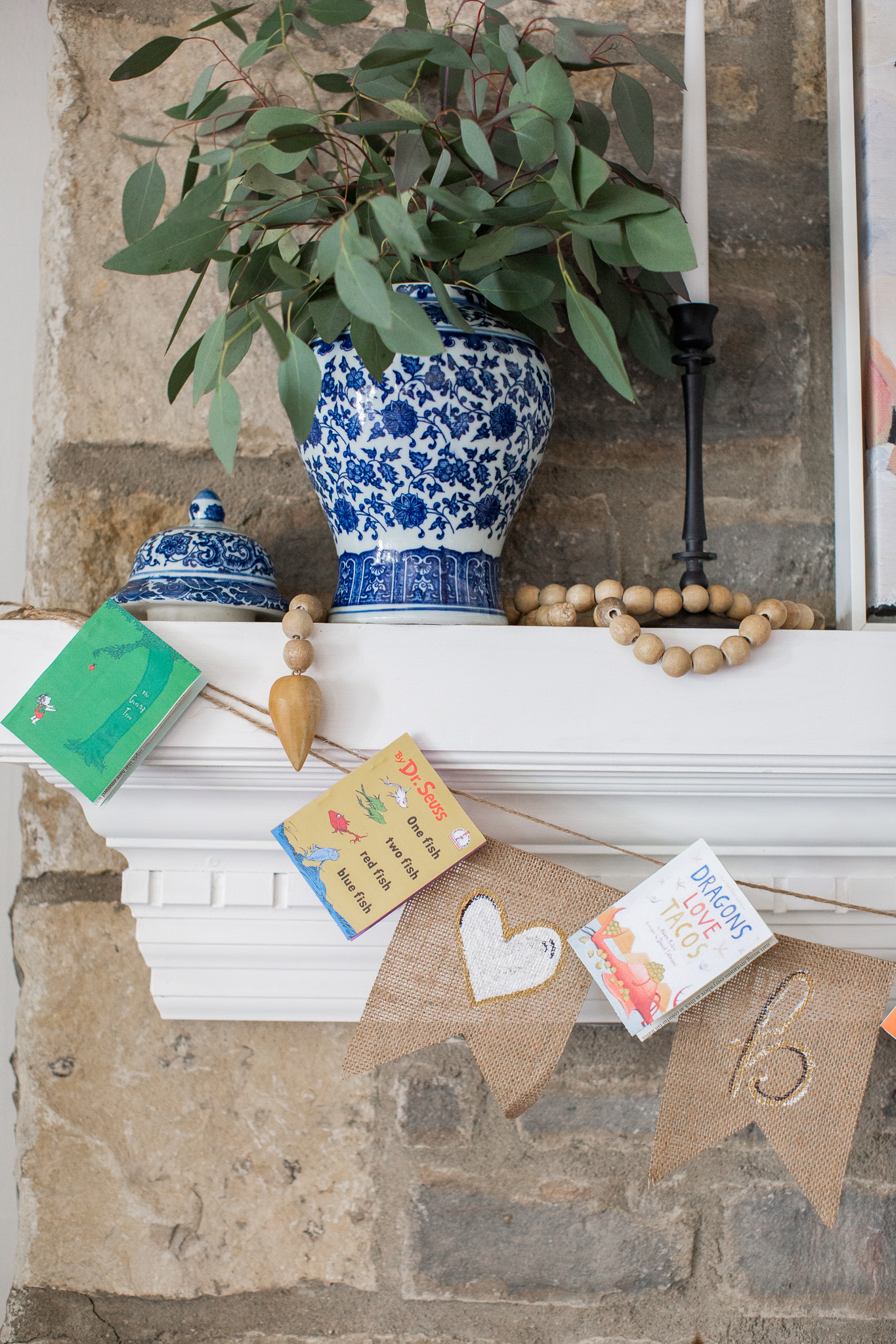  Story Book Baby Shower Ideas by popular North Carolina life and style blog, Coffee Beans and Bobby Pins: image of a children's picture book banner hanging on a fireplace mantle. 