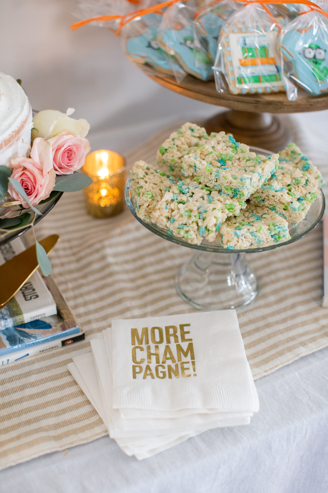  Story Book Baby Shower Ideas by popular North Carolina life and style blog, Coffee Beans and Bobby Pins: image of green and blue rice krispie treats, decorative napkins and book worm cookie favors.