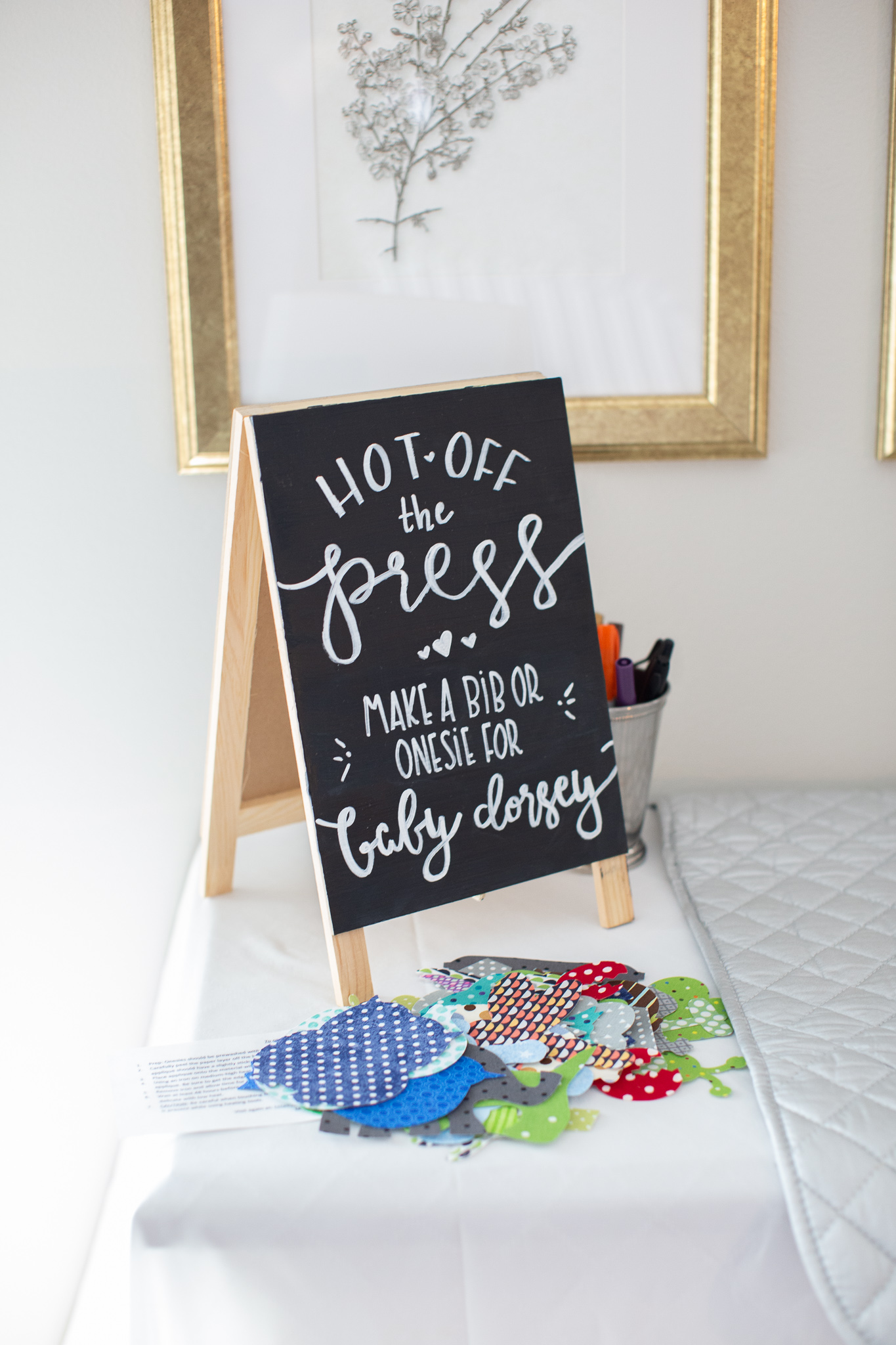  Story Book Baby Shower Ideas by popular North Carolina life and style blog, Coffee Beans and Bobby Pins: image of a onesie decorating station.