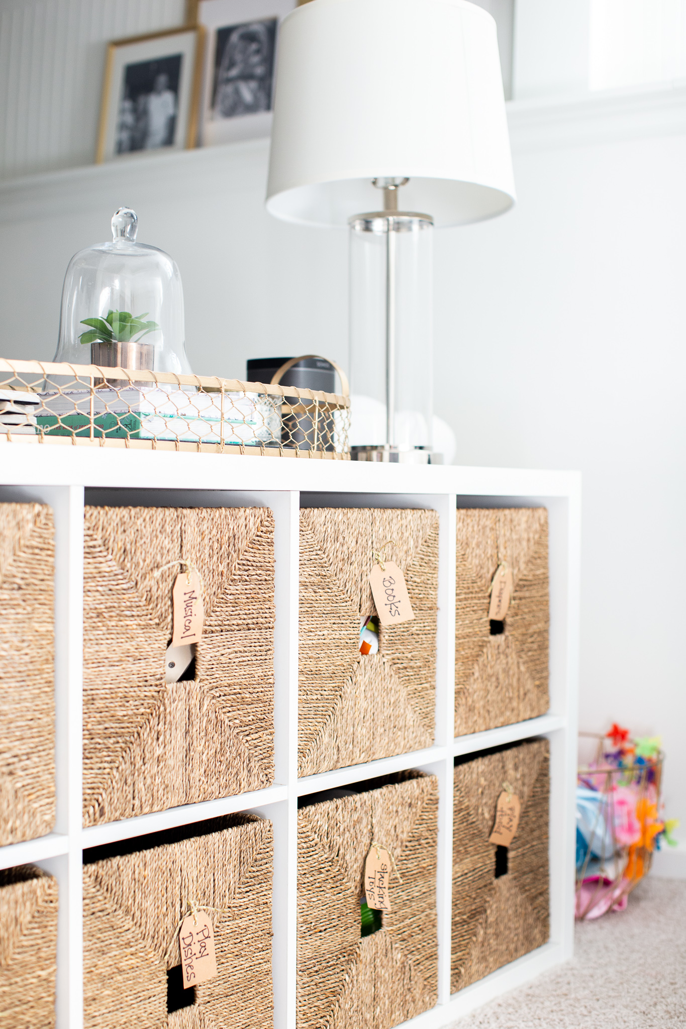 Playroom Storage Ideas and How I Combat All the Toys by popular North Carolina lifestyle blog, Coffee Beans and Bobby Pins: image of a playroom with a storage unit and wicker storage cubes.