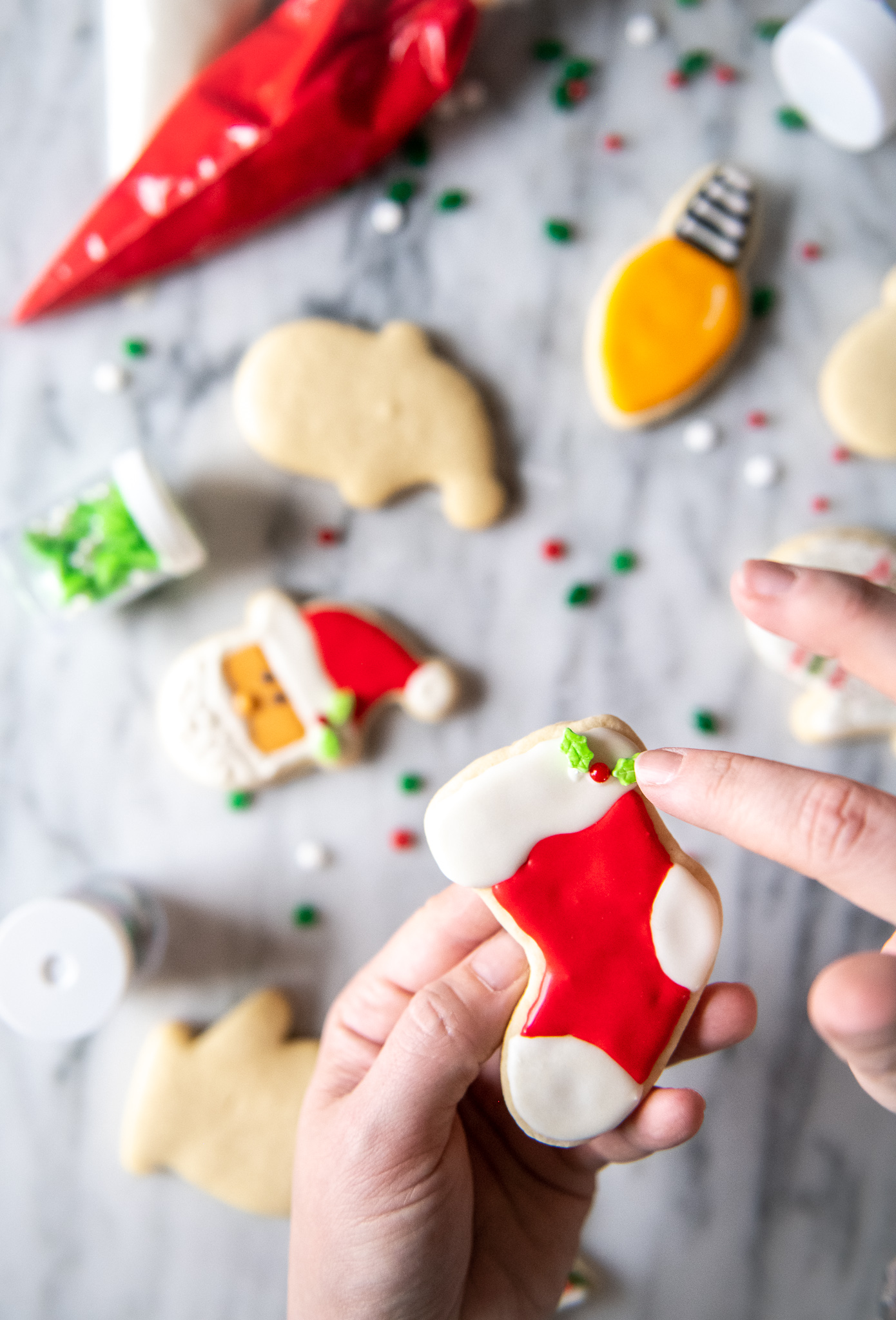 The Best Sugar Cookies With Royal Icing by popular North Carolina lifestyle blog, Coffee Beans and Bobby Pins: image of Christmas sugar cookies with royal icing and Christmas sprinkles.