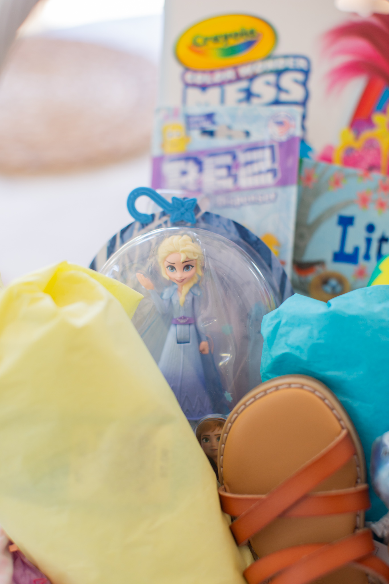 Toddler Easter Basket by popular Ohio lifestyle blog, Coffee Beans and Bobby Pins: image of Amazon Crayola Baby Shark Color Wonder Coloring Pages, Cat & Jack sandals, Forzen II Elsa figure snad Pez dispenser. 