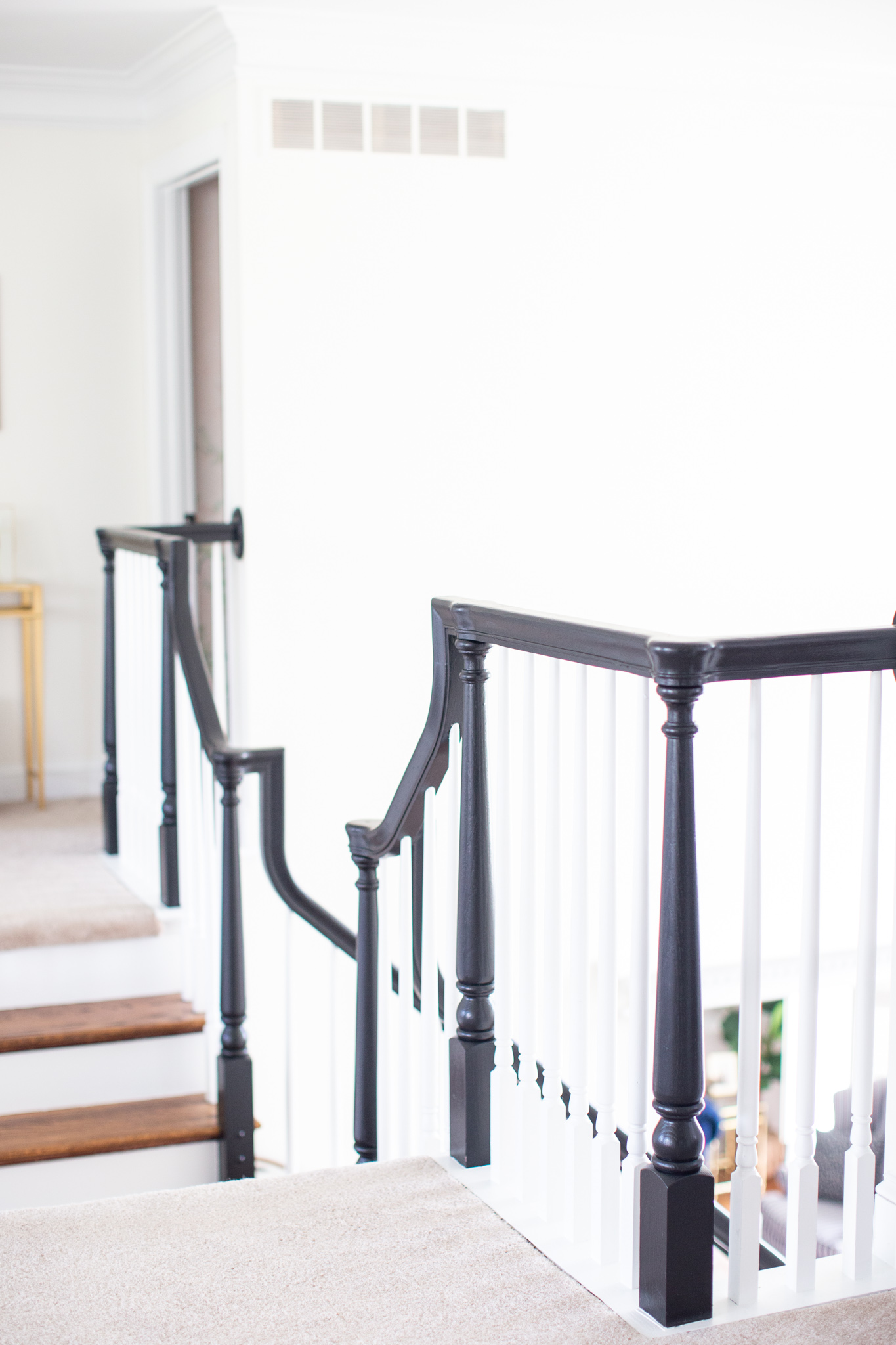 DIY Stair Railing Makeover by popular Ohio DIY blog, Coffee Beans and Bobby Pins: after image of a banister painted with black paint. 