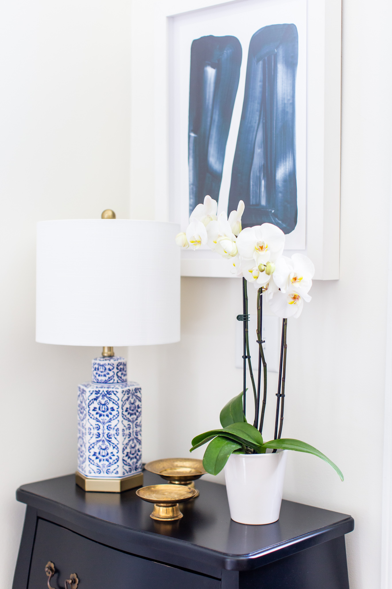 Arhaus Lighting by popular Ohio life and style blog, Coffee Beans and Bobby Pins: image of a entry way decorated with a Arhaus black lines framed print 1, Arhaus bombay small chest, and Arhaus lotus bud vase.