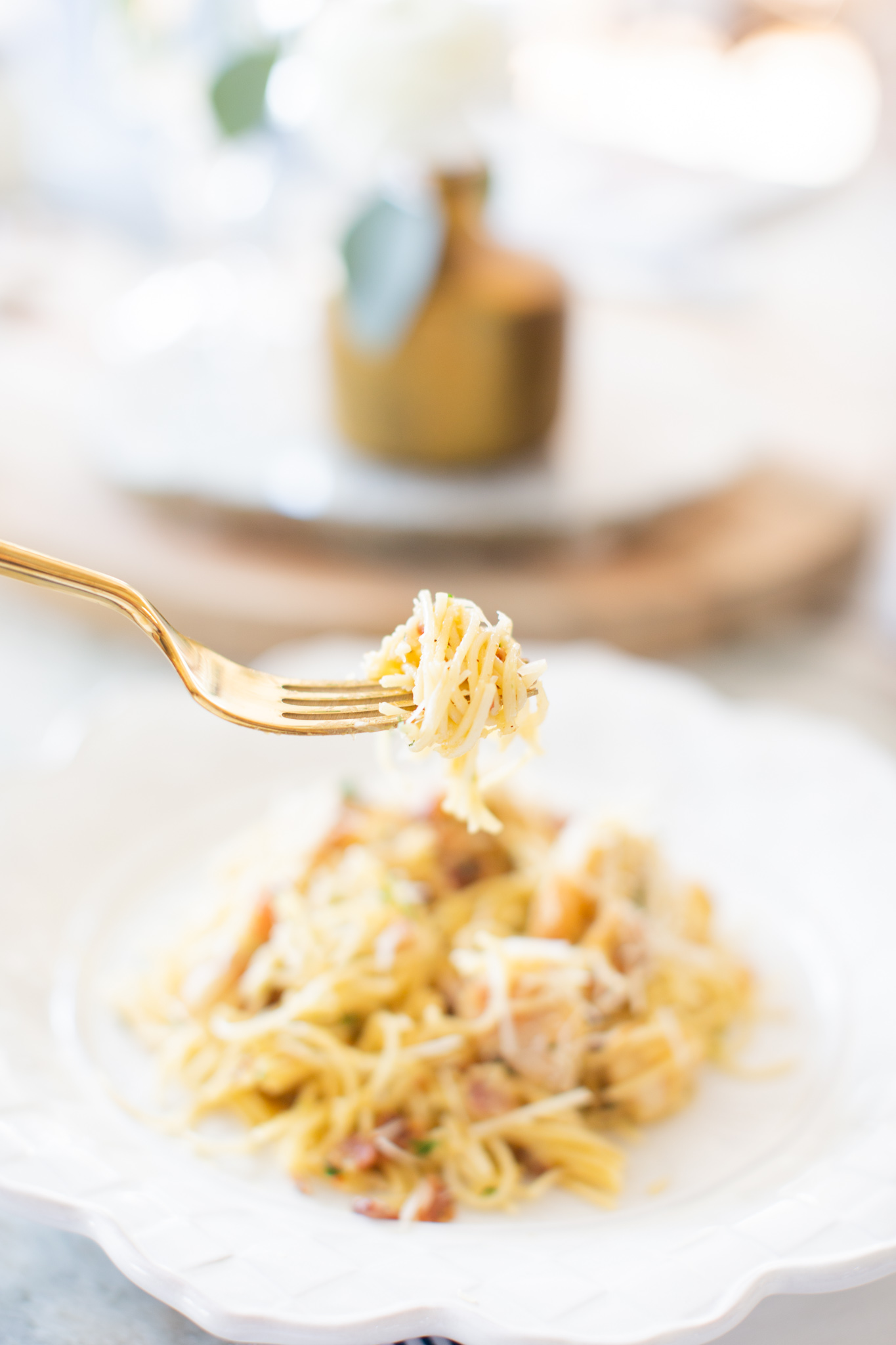 Easy Carbonara Sauce by popular Ohio lifestyle blog, Coffee Beans and Bobby Pins: image of a gold fork holding some pasta with carbonara sauce on it. 
