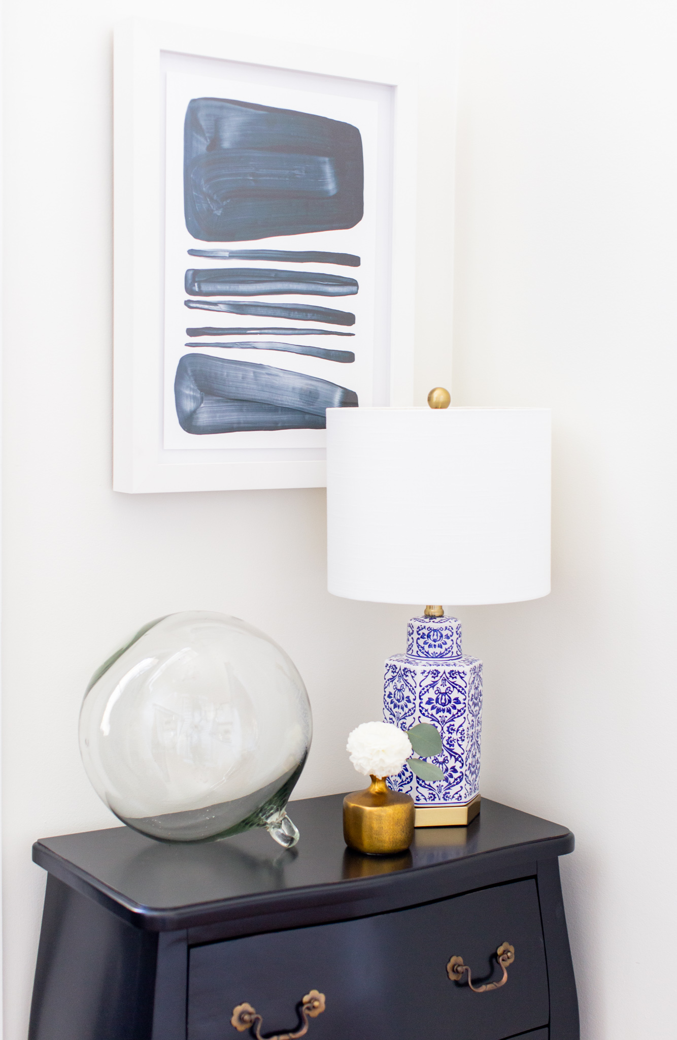 Arhaus Lighting by popular Ohio life and style blog, Coffee Beans and Bobby Pins: image of a entry way decorated with a Arhaus rug, Arhaus black lines framed print 1, Arhaus bombay small chest, and Arhaus lotus bud vase.