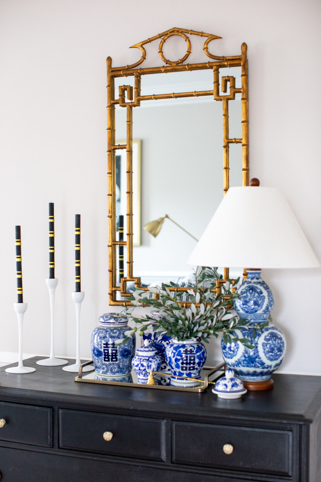 Mixing Old and New Furniture by popular Ohio life and style blog, Coffee Beans and Bobby Pins: image of a vintage blue and white ginger jars, white Ikea candlesticks, black dresser, and bamboo mirror.