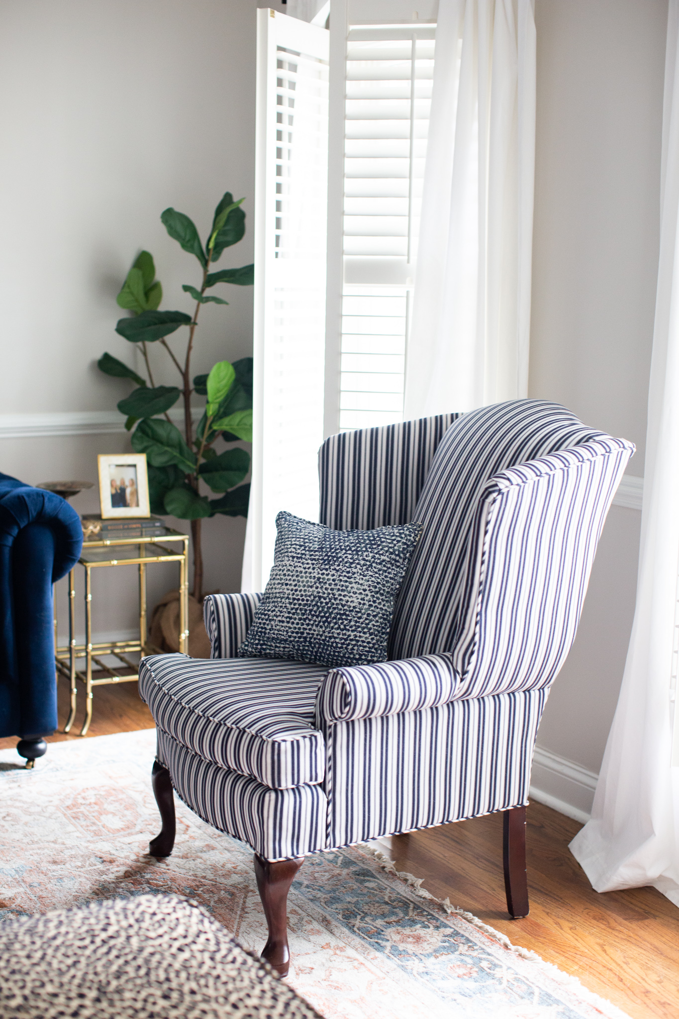 Mixing Old and New Furniture by popular Ohio life and style blog, Coffee Beans and Bobby Pins: image of a antique wing back shair recovered in blue and white stripe fabric.  