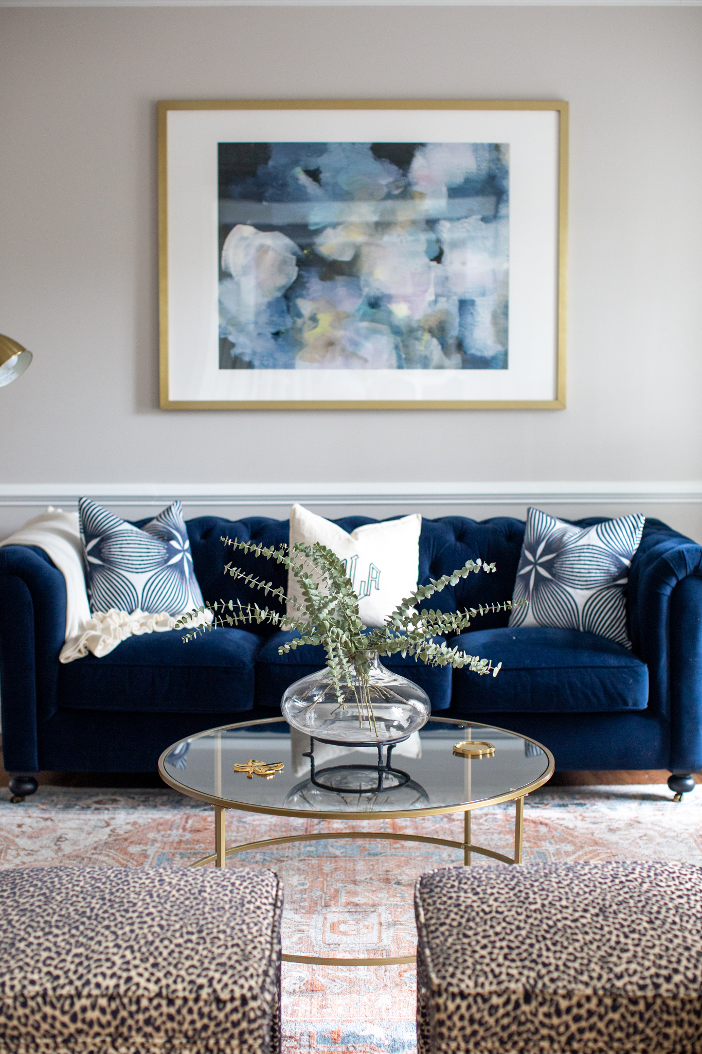 Mixing Old and New Furniture by popular Ohio life and style blog, Coffee Beans and Bobby Pins: image of a blue velvet couch, leopard print ottomans, and a glass coffee table. 
