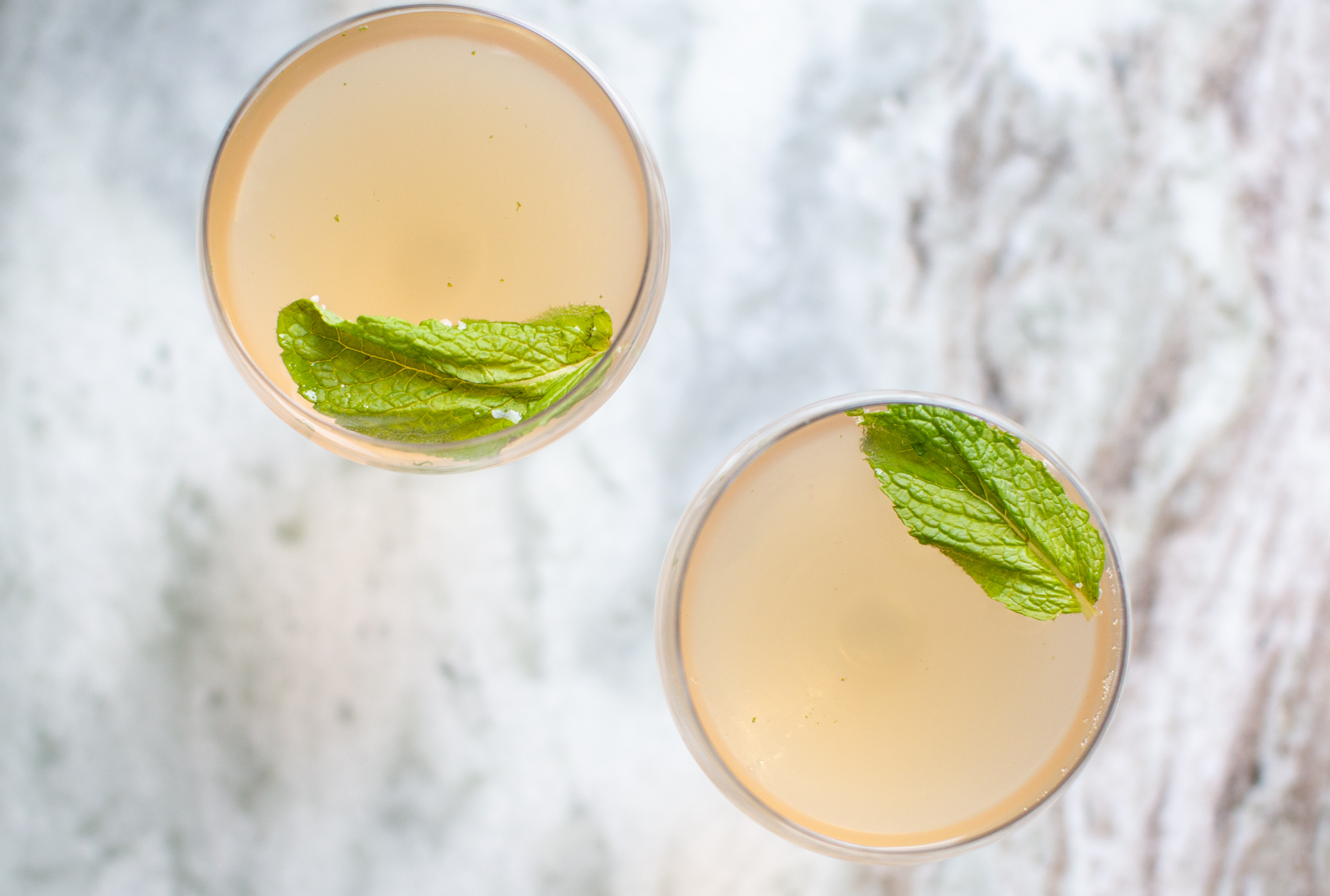 Rum Cocktail by popular Ohio lifestyle blog, Coffee Beans and Bobby Pins: image of a Old Cuban Rum Cocktail in a martini glass with a mint leaf floating on top. 