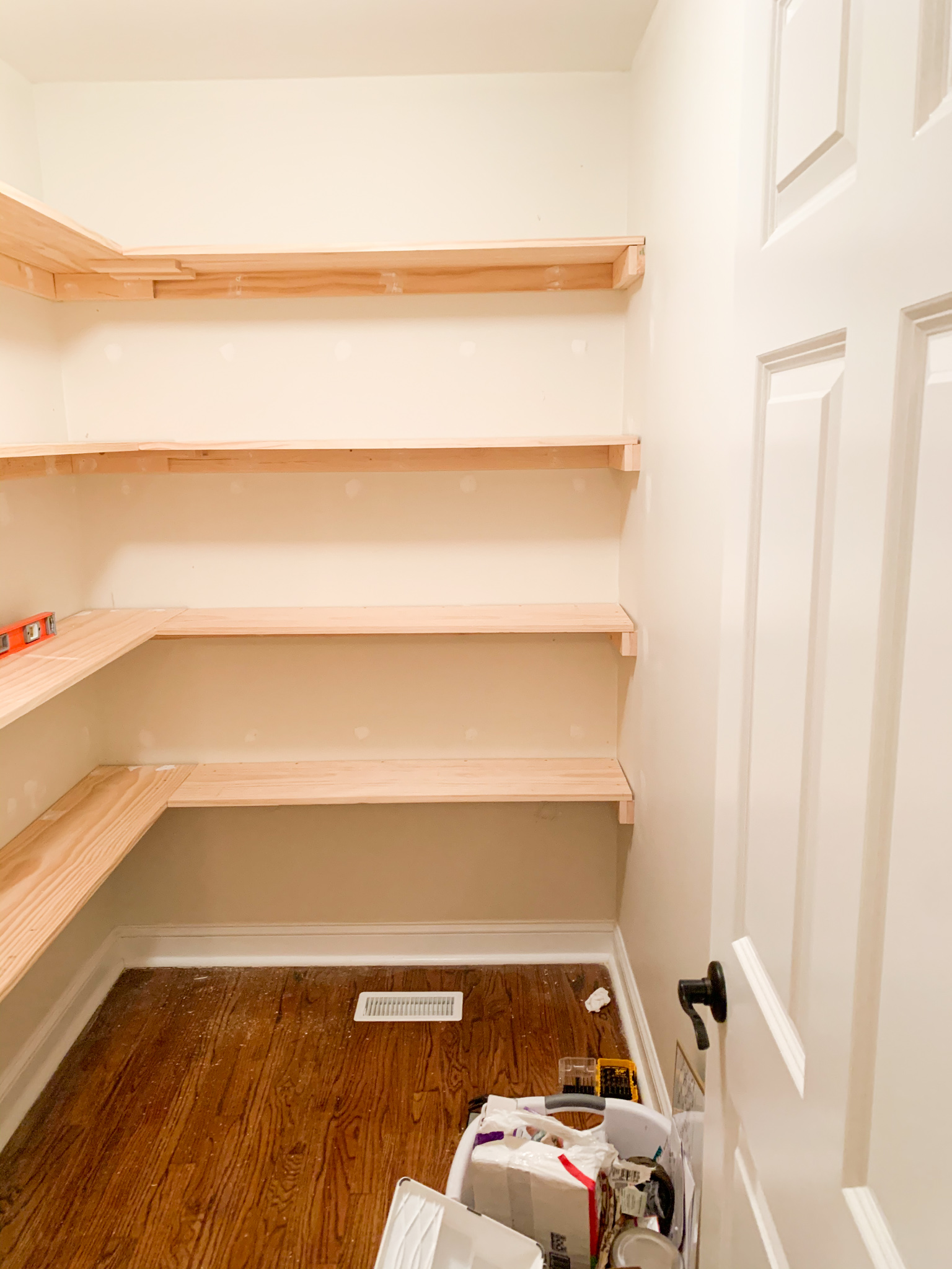 DIY Pantry Shelves by popular Ohio DIY lifestyle blog, Coffee Beans and Bobby Pins: image of a walk-in pantry with wooden shelving. 