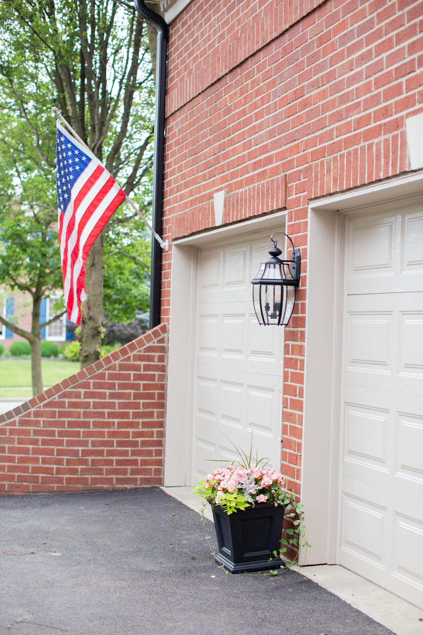 Front Porch by popular Ohio life and style blog, Coffee Beans and Bobby Pins: image of the front of a house decorated with an American flag and Grandin Road Devon Tapered Planter.