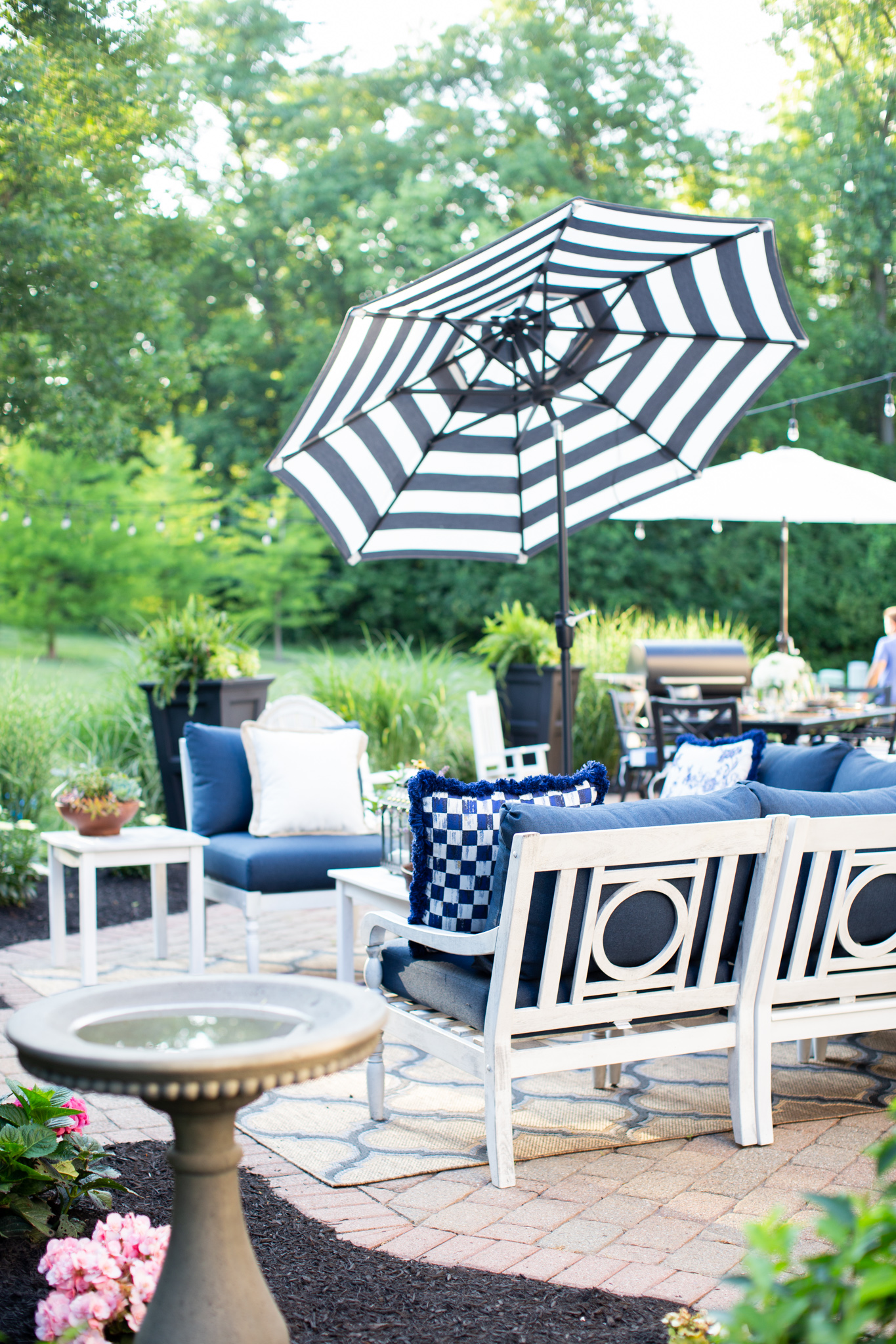 Back Patio by popular Ohio life and style blog, Coffee Beans and Bobby Pins: image of a back patio decorated with a Grandin Road Yorkshire Outdoor Sectional Collection, Grandin Road Octagonal Outdoor Market Umbrella, and Grandin Road rug, and Grandin Road Trenton Fire Pit. 