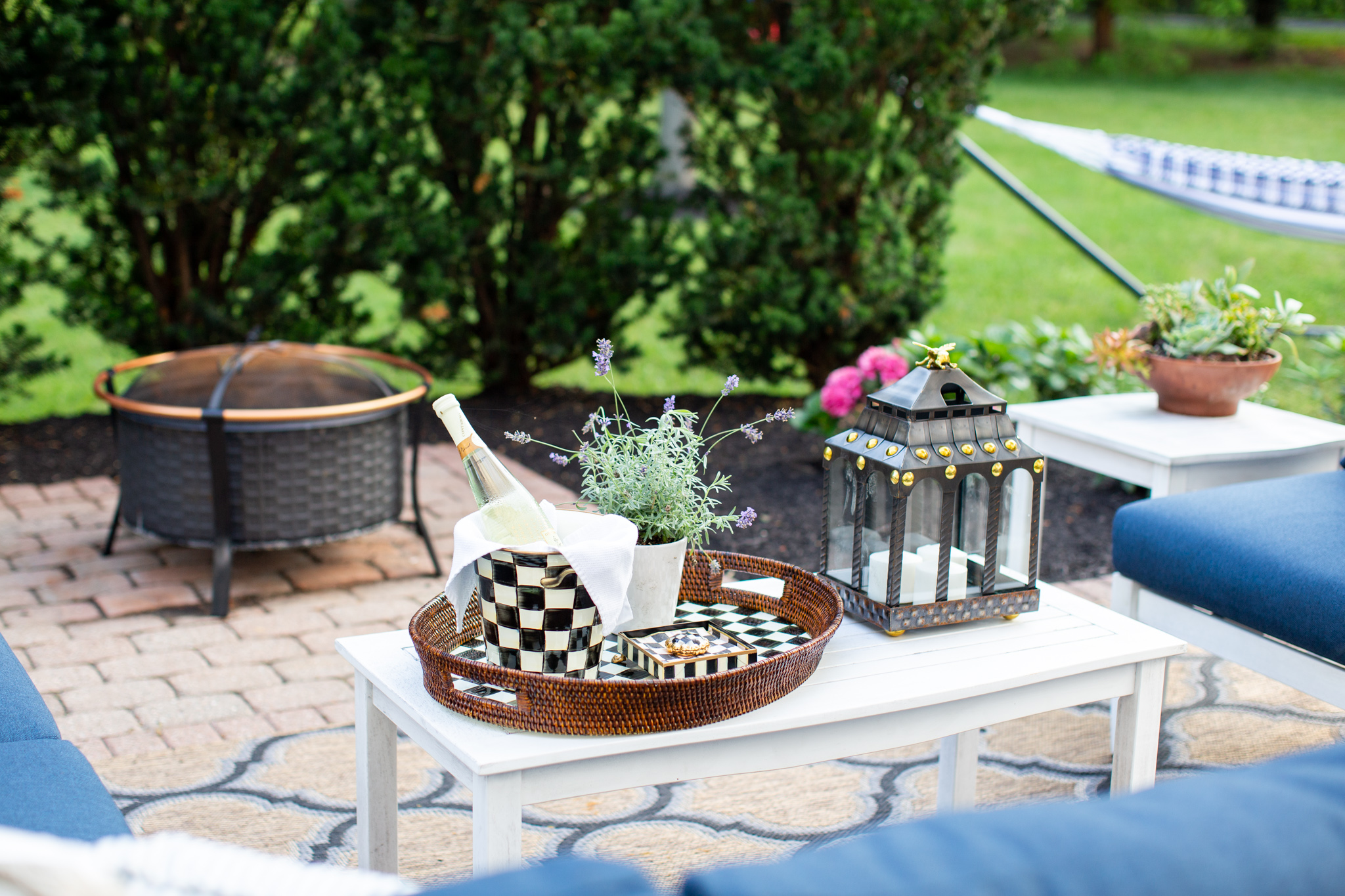 Back Patio by popular Ohio life and style blog, Coffee Beans and Bobby Pins: image of a back patio decorated with a Grandin Road Yorkshire Outdoor Sectional Collection, Grandin Road Octagonal Outdoor Market Umbrella, and Grandin Road rug, and Grandin Road Trenton Fire Pit. 