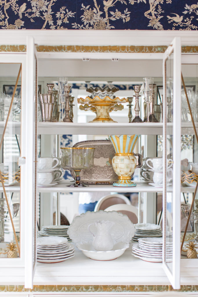 Blue Floral Wallpaper by popular Ohio life and style blog, Coffee Beans and Bobby Pins: image of a white china hutch with various china pieces and porcelain dishes. 