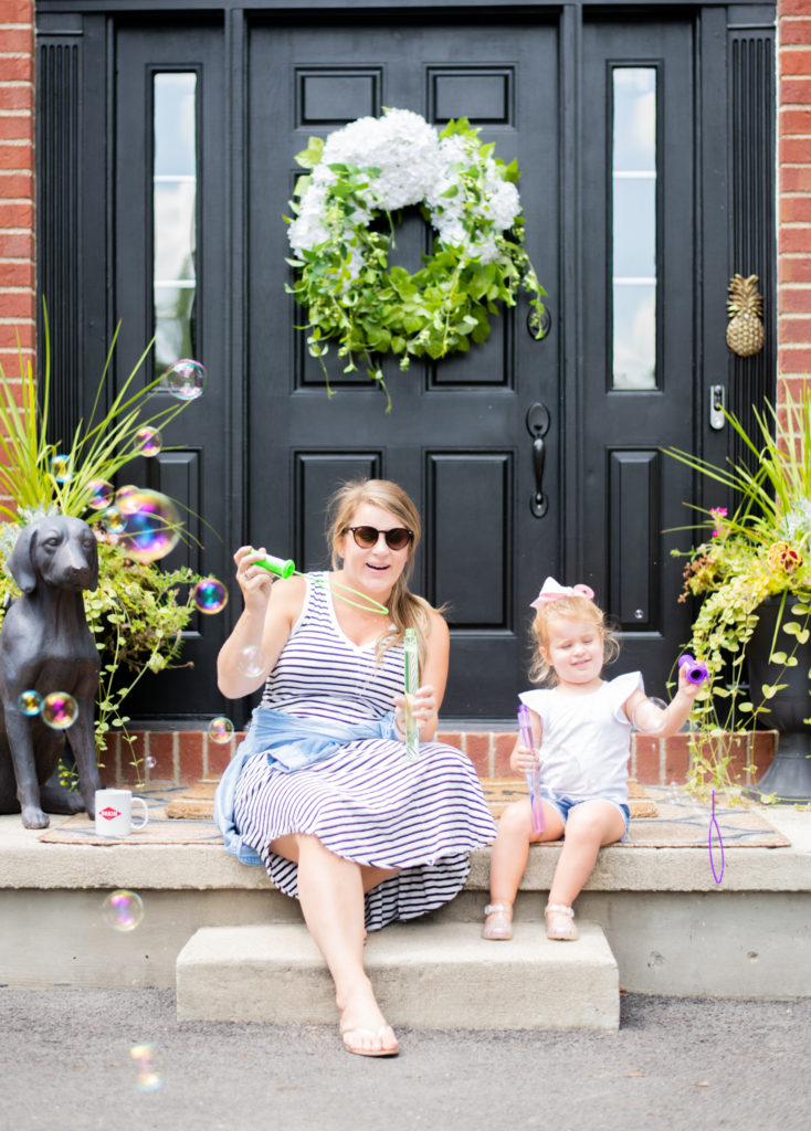 Deep Clean by popular Ohio lifestyle blog, Coffee Beans and Bobby Pins: image of a mom and her daughter sitting on their front porch and blowing bubbles. 