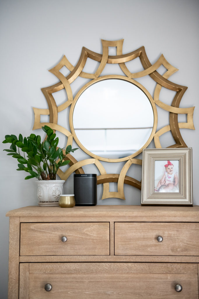 Master Bedroom Remodel Ideas by popular Ohio lifestyle blog, Coffee Beans and Bobby Pins: image of ornate round gold mirror hanging above a wooden dresser. 