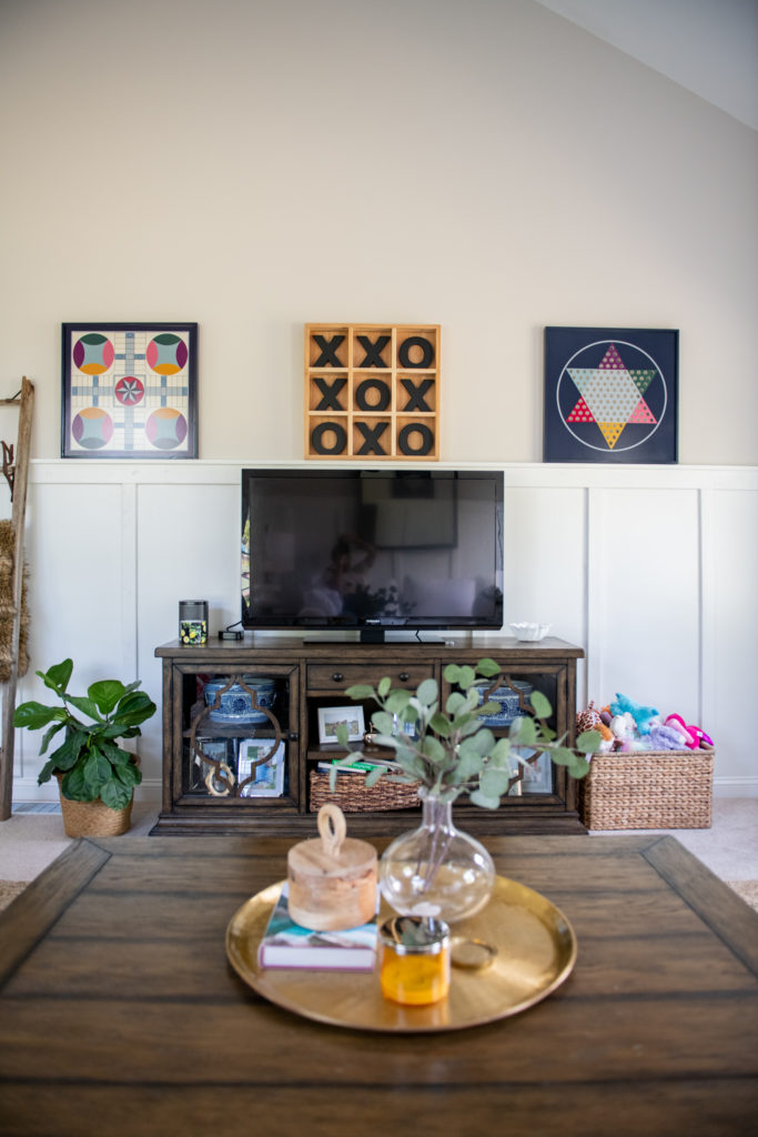 Art Display Ideas by popular Ohio life and style blog, Coffee Beans and Bobby Pins: image of playroom decorated with Grandin Road gameboard trays, XOXO board, blanket ladder, blue and white stripe blanket, fiddle leaf fig plant in a woven plant holder, and a flat screen T.V..