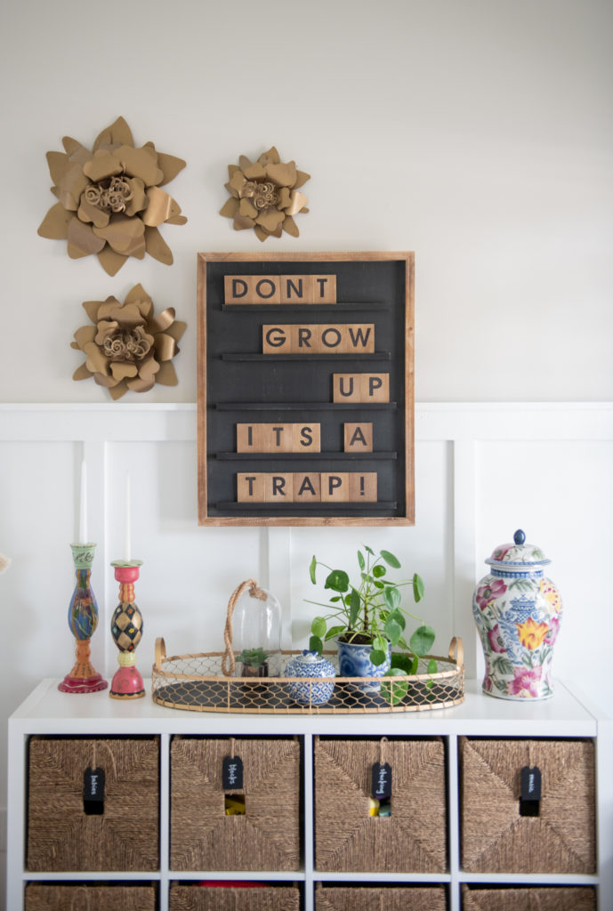 Art Display Ideas by popular Ohio life and style blog, Coffee Beans and Bobby Pins: image of a playroom decorated with a letterboard, gold wall flowers, wire basket, blue and white china pottery and a cube storage unit. 