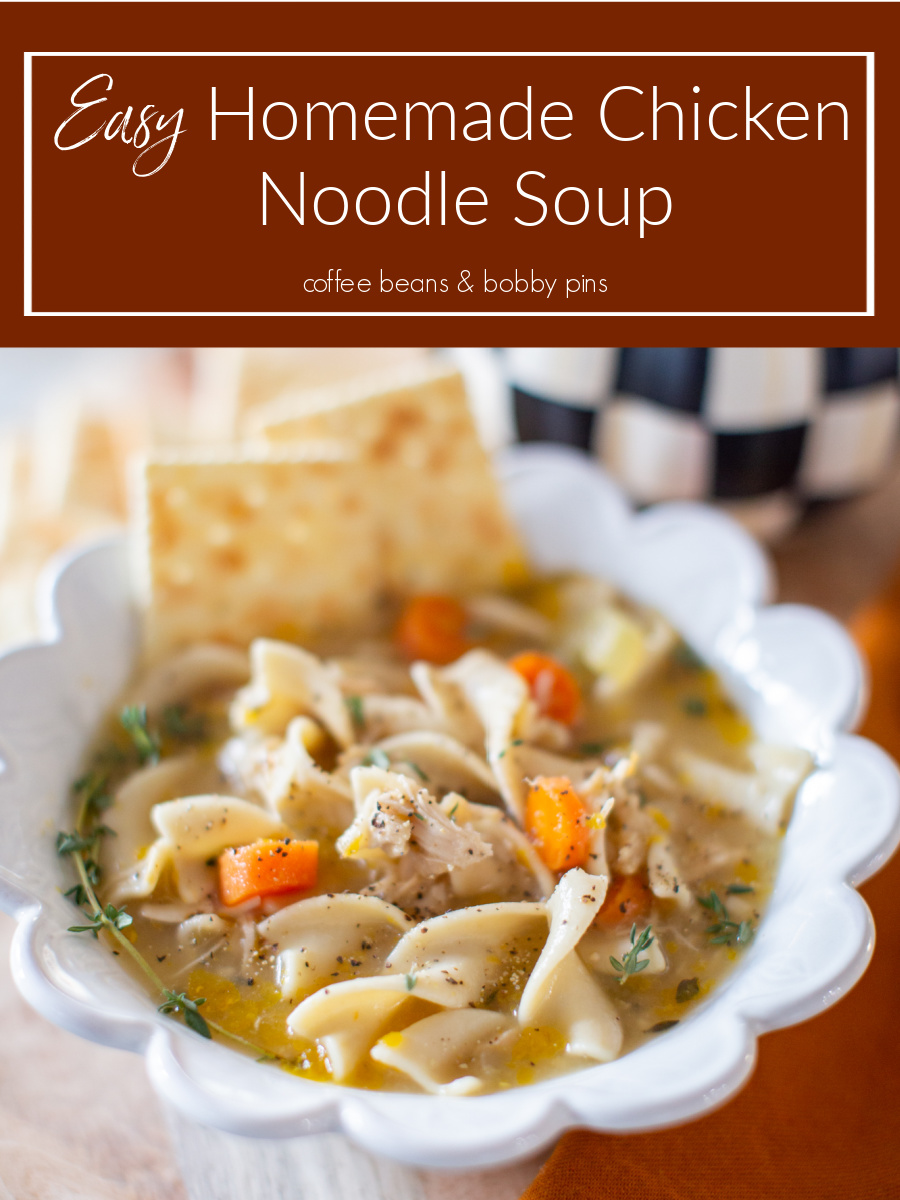 Homemade Chicken Noodle Soup by popular Ohio lifestyle blog, Coffee Beans and Bobby Pins: image of homemade chicken noodle soup in a white scallop edge bowl next to an orange cloth napkin, gold spoon, and pile of soda crackers. 