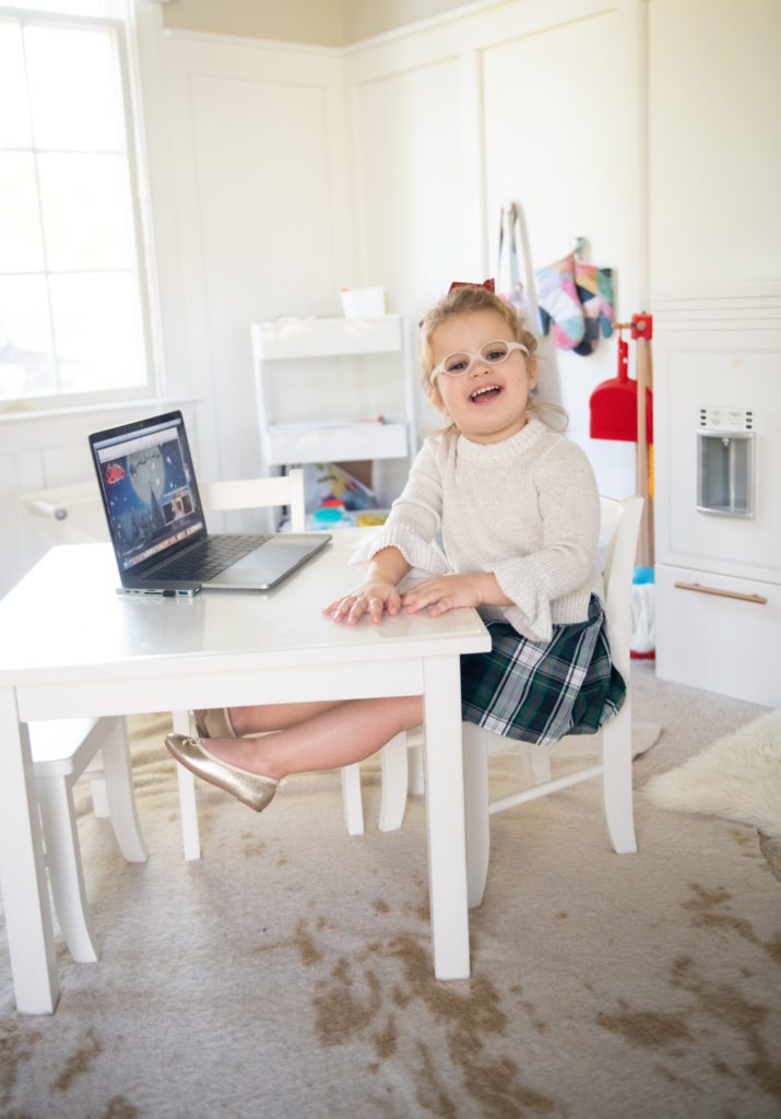Talk to Santa by popular Ohio lifestyle blog, Coffee Beans and Bobby Pins: image of a young girl sitting at a kiddie table in a playroom in front of an open laptop. 
