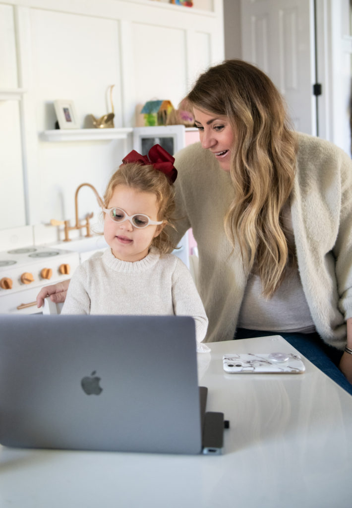 Talk to Santa by popular Ohio lifestyle blog, Coffee Beans and Bobby Pins: image of a mom and her young daughter sitting together in a playroom in front of an open laptop. 