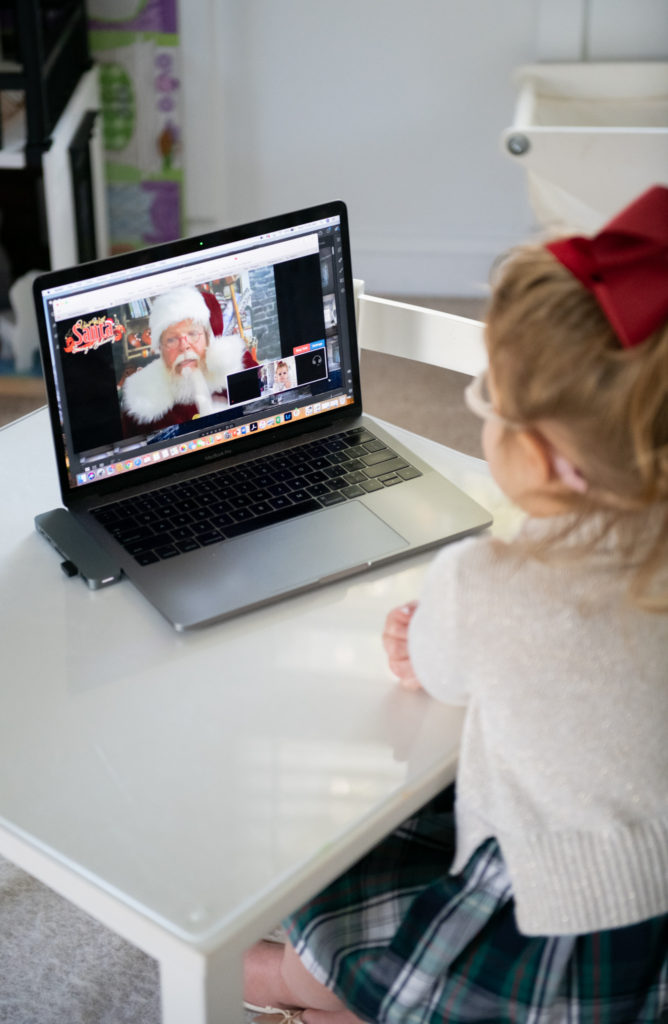 Talk to Santa by popular Ohio lifestyle blog, Coffee Beans and Bobby Pins: image of a young girl sitting at a kiddie table in a playroom in front of an open laptop. 