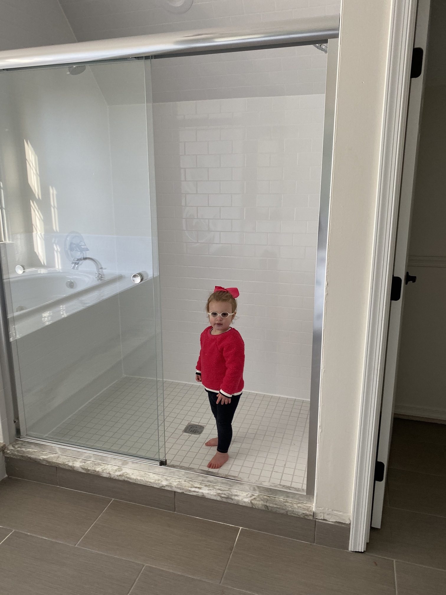 Master Bedroom Remodel by popular Ohio life and style blog, Coffee Beans and Bobby Pins: image of a little girl standing in a shower. 