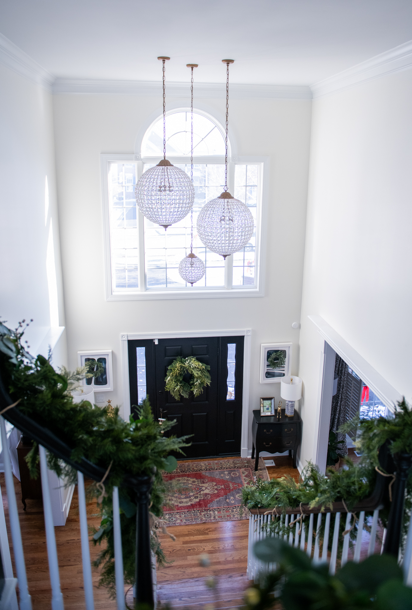 Christmas Home Decor Ideas by popular Ohio life and style blog, Coffee Beans and Bobby Pins: image of a entry way decorated with garland and a Christmas wreath. 
