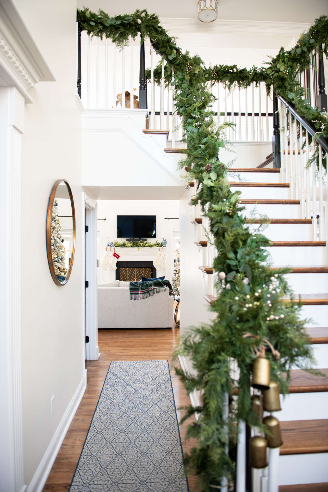 Christmas Home Tour by popular Ohio life and style blog, Coffee Beans and Bobby Pins: image of a banister decorated with a Grandin Road garland. 