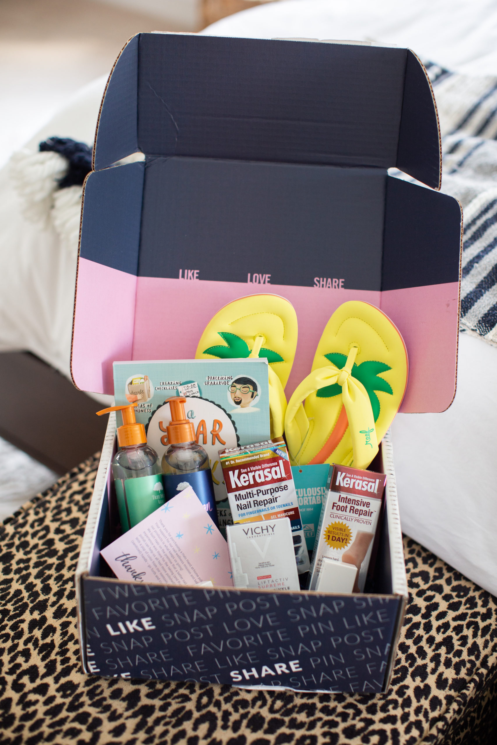 Springtime Products by popular Ohio life and style blog, Coffee Beans and Bobby Pins: image of a Babbleboxx filled with Kerasal foot products, Reef flip flops, Vichy lift active wrinkle cream, a year in a week book, and Tree Hut shave oil. 