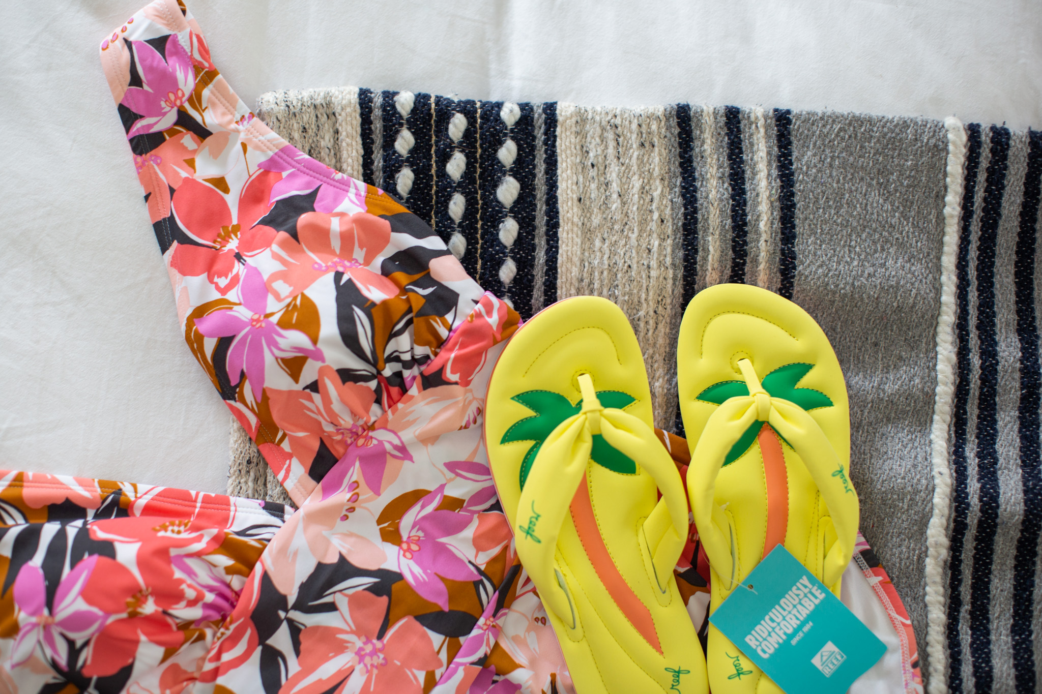 Springtime Products by popular Ohio life and style blog, Coffee Beans and Bobby Pins: image of Reef float sandals and a floral print one piece swimsuit.