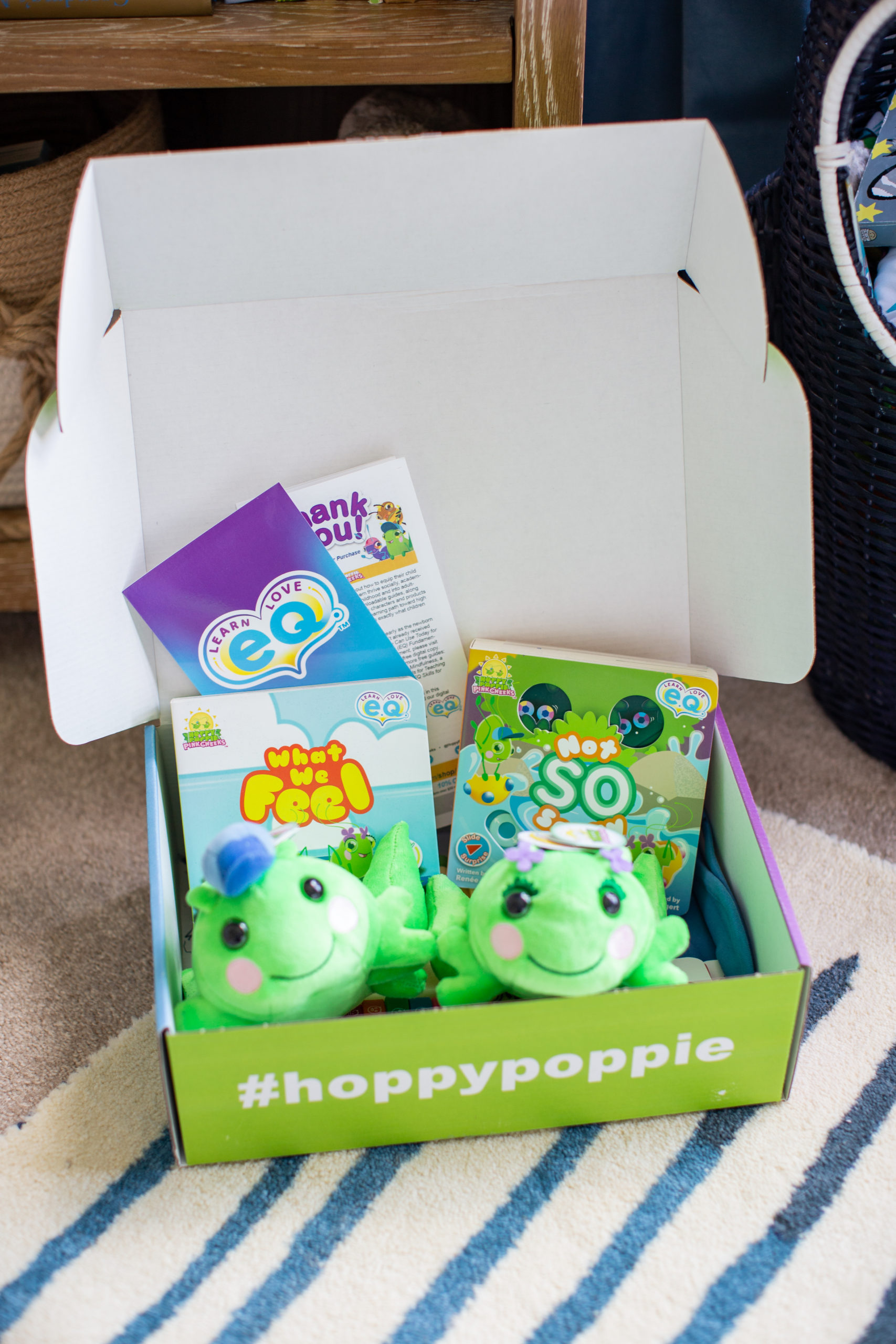 Mommy and Me by popular Ohio motherhood blog, Coffee Beans and Bobby Pins: image of a hoppy poppy box filled with stuffed frogs and what we feel book.