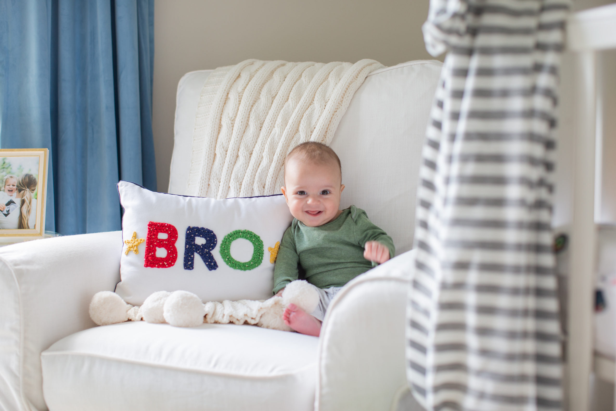 Mommy and Me by popular Ohio motherhood blog, Coffee Beans and Bobby Pins: image of a baby boy sitting on a white armchair next to a bro throw pillow. 