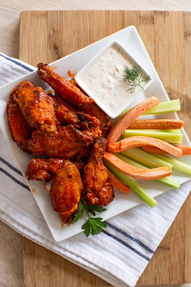 Air Fried Chicken Wings by popular Ohio lifestyle blog, Coffee Beans and Bobby Pins: image of a plate of air fried chicken wings, carrot sticks, and celery sticks. 